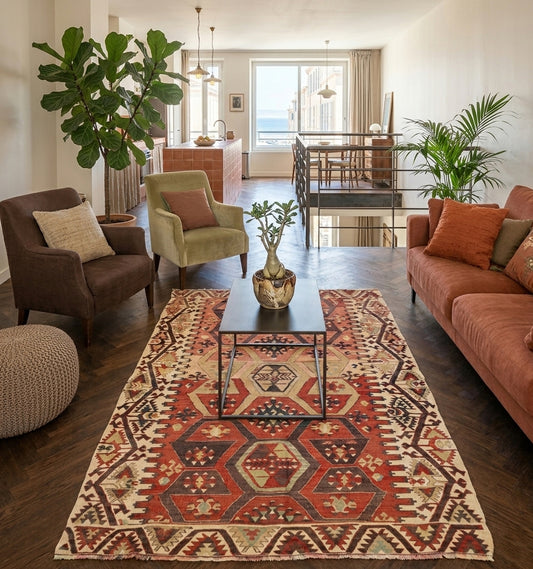 Tapis kilim Adana vintage de 65 ans aux motifs hexagonaux et tons terre de Sienne, tissé main en Anatolie. Cette pièce d'artisanat d'exception sublime un grand loft avec vue mer à Marseille, offrant un contraste chaleureux entre l'héritage nomade turc, un parquet en chevrons sombre et un mobilier contemporain chic.