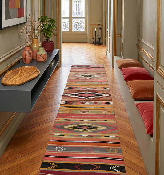 Tapis de couloir (runner) en laine Denizli aux motifs ethniques rose et noir (270 x 61 cm) à Paris mis en situation dans un couloir lumineux haussemanien avec moulure et murs vert