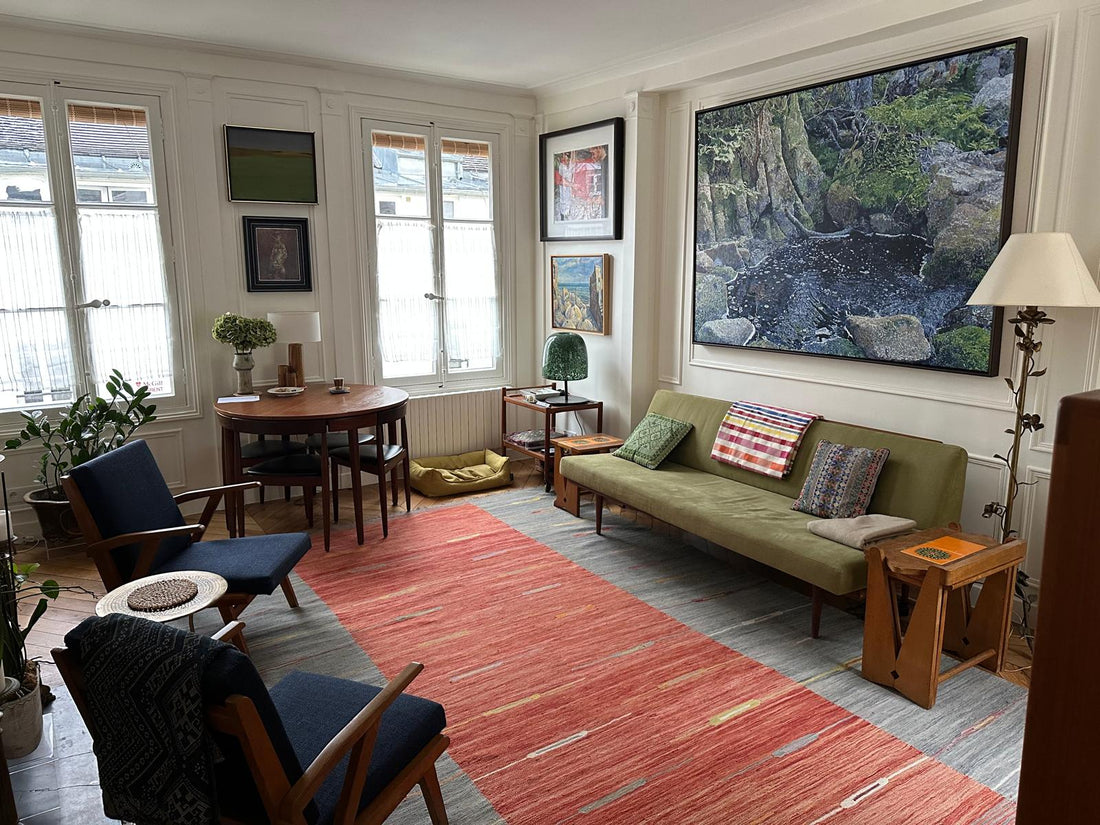 Kilim Art Déco 300x200 cm dans un salon parisien du 6ème, posé sous un canapé vert kaki et fauteuils vintage, grande toile contemporaine au mur