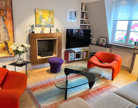 Kilim Art Déco 190x130 cm dans un salon à Paris 15ème, fauteuils orange, pouf violet, table basse en verre, cheminée en bois