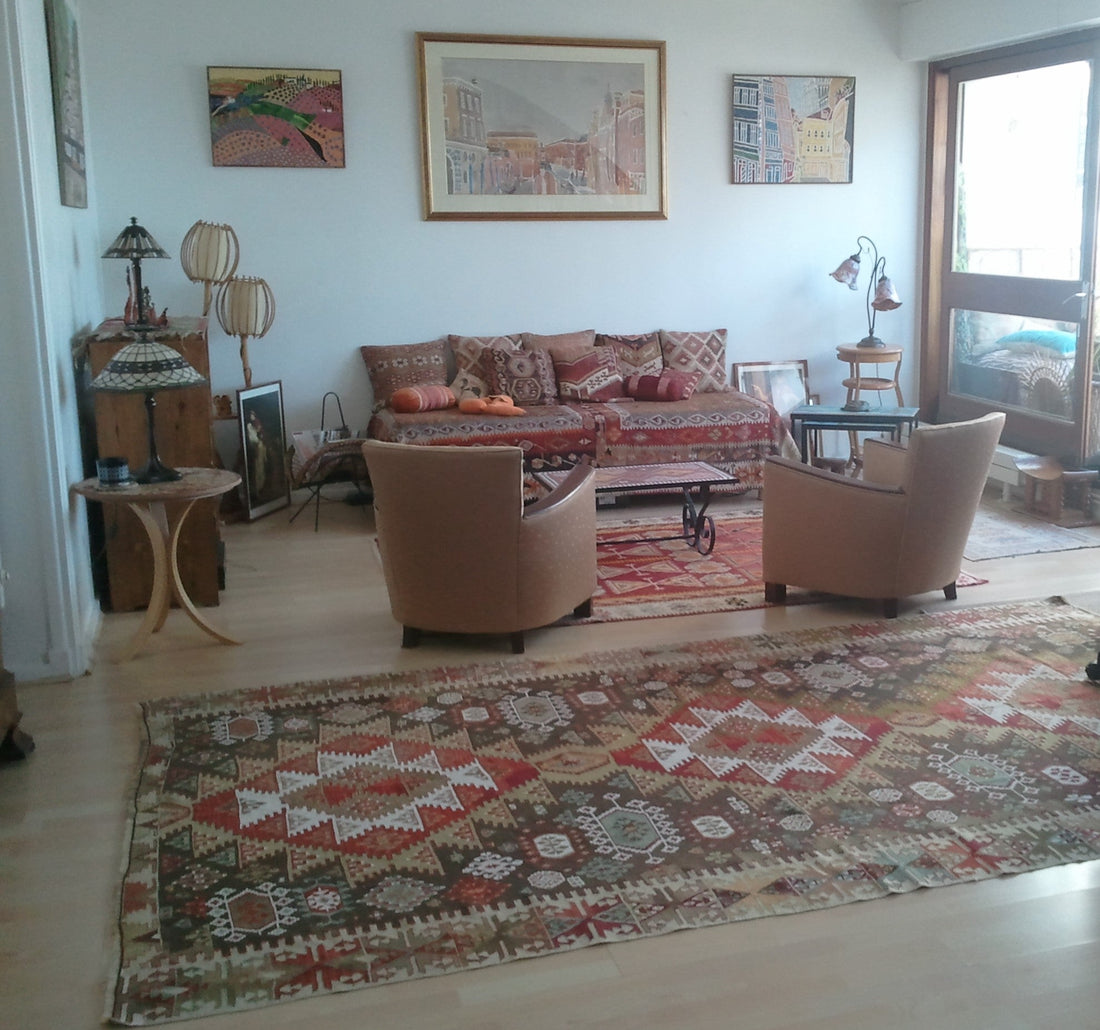 Kilim ancien Sivas 310x185 cm dans un salon à Paris 16ème, fauteuils arrondis, tableaux anciens, second kilim sous la table basse