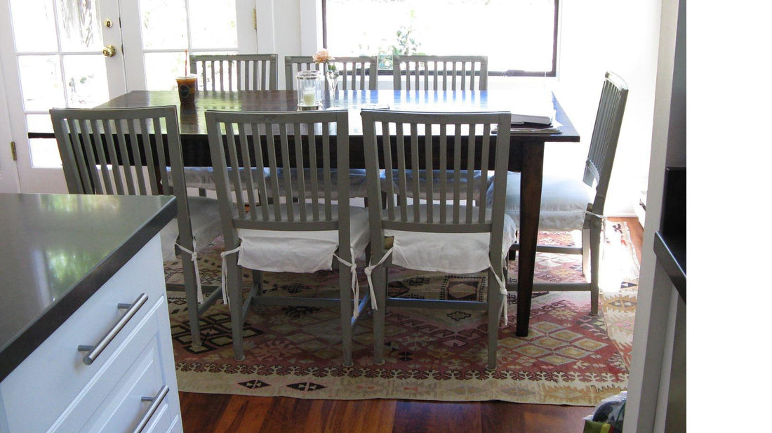 Kilim ancien Adana 280x170 cm dans une salle à manger à Miami, table en bois sombre, chaises grises à barreaux, cuisine ouverte