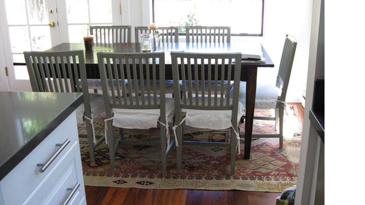 Kilim ancien Adana 280x170 cm dans une salle à manger à Miami, table en bois sombre, chaises grises à barreaux, cuisine ouverte