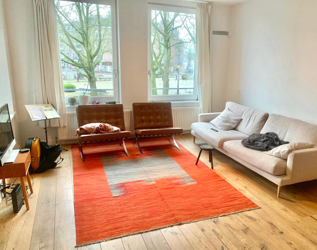 Kilim contemporain Art Déco 290x190 cm dans un salon à Londres, parquet blond, fauteuils cuir vintage, canapé gris, grandes fenêtres