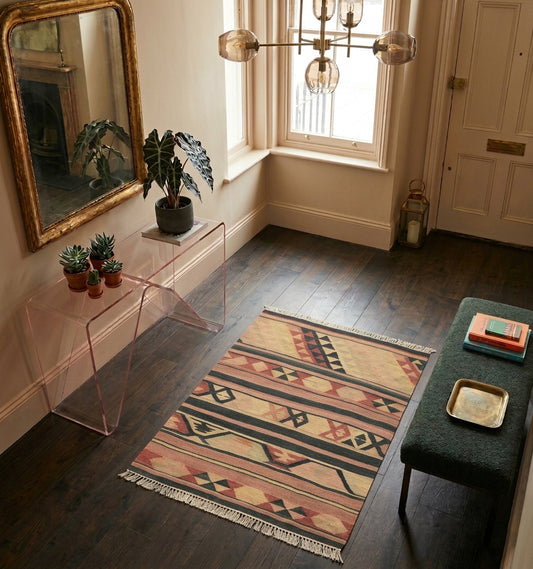 Tapis Kilim Adana vintage en laine, motifs géométriques noirs et rouges, posé sur parquet foncé dans une entrée élégante