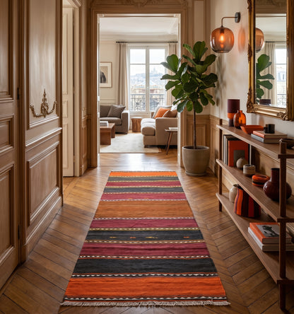 Kilim ancien d'Adana, Anatolie, à rayures orange, bordeaux et anthracite tissé main en laine naturelle, en couloir dans un appartement haussmannien à Paris.