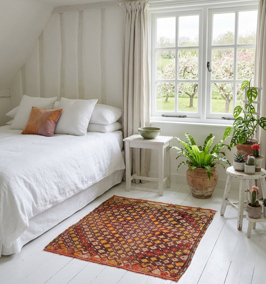 Kilim Cicim ancien en laine aux tons terre de Sienne et ocre, tissage artisanal d'Anatolie à motifs losanges, sublimant une chambre blanche lumineuse au style bohème chic et naturel.