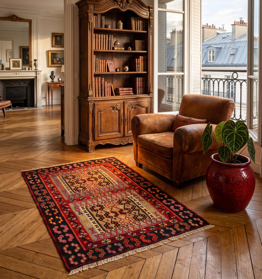 Tapis Kilim Kayseri vintage en laine aux motifs rouges et noirs étendu dans un salon à Paris baroque, avec un joli parquet