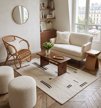 Kilim patchwork en chanvre, tapis contemporain tissé main à partir de kilims anciens d'Anatolie recomposés, motif rayé écru et brun posé sur parquet en chevrons dans un salon parisien avec vue sur les toits de Montmartre
