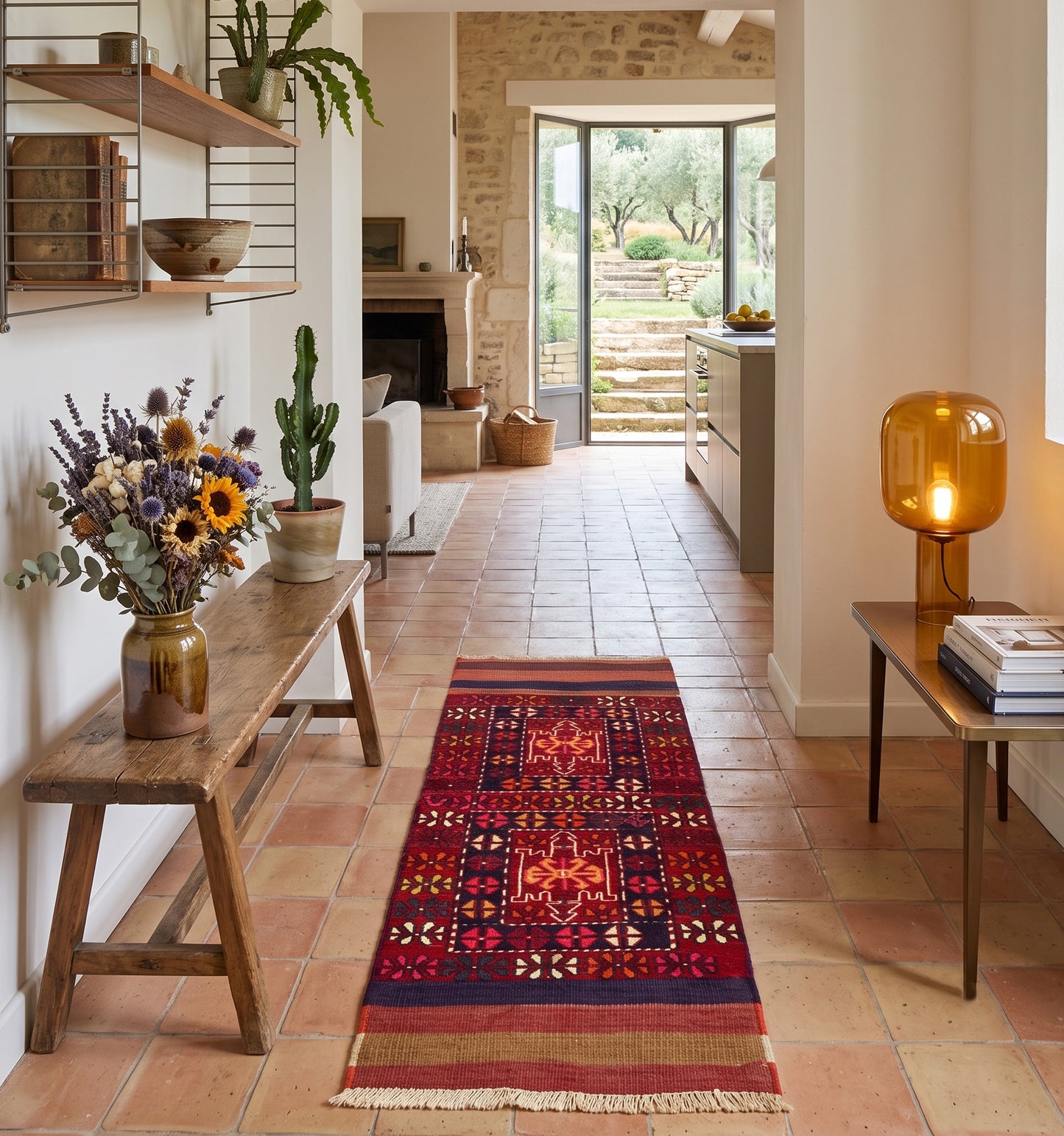 Tapis kilim soumak ancien tissé main par des nomades d'Anatolie, technique rare et motifs géométriques hérités des tisserands, posé dans un couloir de mas en pierre du Luberon, fragment d'histoire entre pierre et olivier