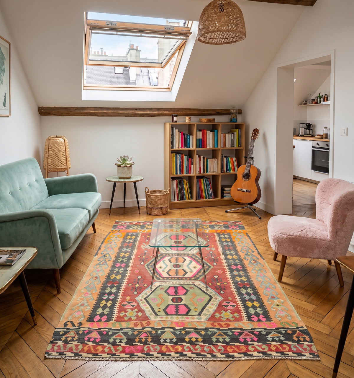 Tapis kilim ancien de Corum, tissé main en laine par des nomades d'Anatolie, médaillons hexagonaux rose et vert amande sur fond corail, posé dans un appartement à Montmartre sous velux face à une bibliothèque et une guitare classique