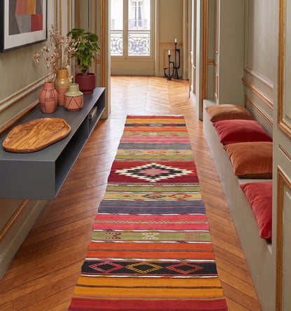 Tapis de couloir (runner) en laine Denizli aux motifs ethniques rose et noir (267 x 55 cm) à Paris mis en situation dans un couloir lumineux haussemanien avec moulure et murs vert