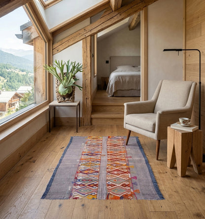 Tapis kilim Cuval vintage de 60 ans, tissé à la main en Anatolie avec des pigments naturels. Ce petit format aux motifs losanges est mis en valeur dans un chalet de luxe à Megève, apportant une chaleur artisanale et un caractère authentique à une chambre moderne en bois clair.