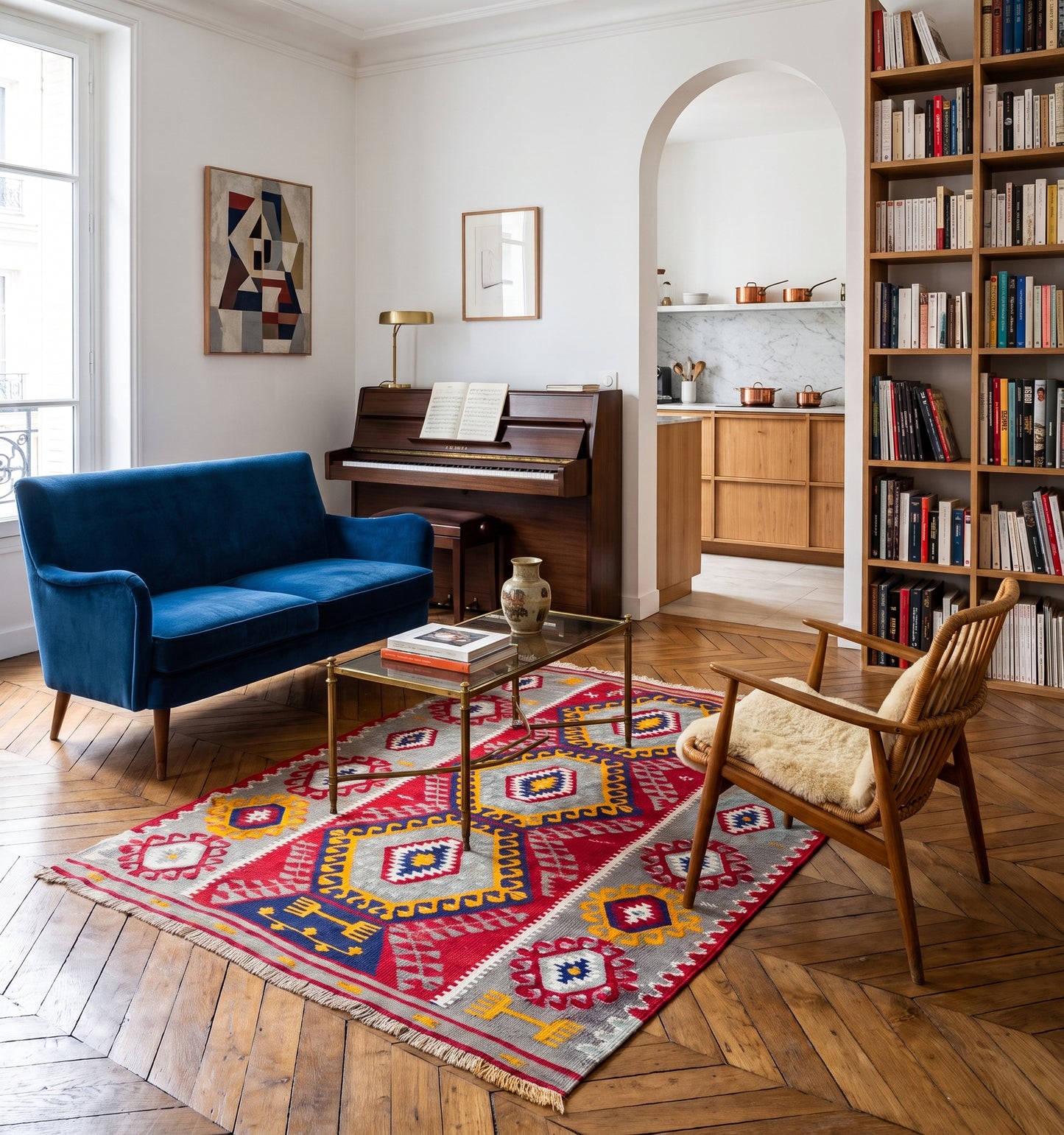 Tapis kilim ancien de Denizli, tissé main en laine par des nomades d'Anatolie, médaillons rouge et safran sur fond gris perle, posé dans un salon strasbourgeois face à un piano droit et une bibliothèque garnie