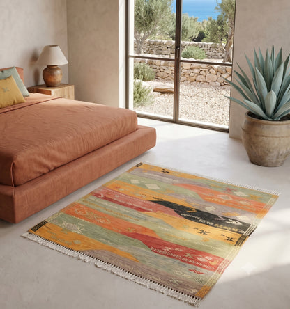 Tapis kilim Denizli ancien au format carré (112x108cm), orné de motifs géométriques et de losanges traditionnels. Tissé à la main en laine de haute qualité avec des teintures végétales aux nuances terracotta, indigo et ocre, cette pièce artisanale turque apporte une touche bohème authentique à une villa lumineuse à Ibiza. Elle sublime un espace de vie aux murs en chaux blanche, contrastant avec le sol en pierre naturelle et un mobilier en bois flotté.