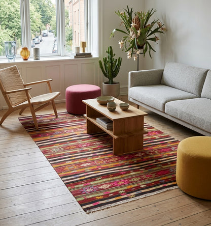 Tapis kilim Fethiye vintage de 60 ans aux rayures horizontales multicolores et motifs ethniques délicats, tissé à la main en Anatolie. Cette pièce artisanale apporte une touche bohème-chic à un salon moderne à Lyon, créant un contraste chaleureux avec un parquet clair, un mobilier minimaliste et une décoration végétale soignée.