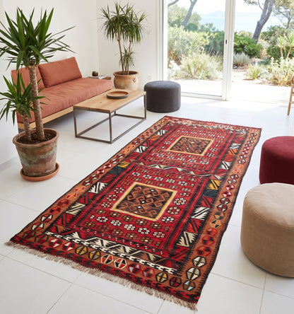 Tapis kilim Kayseri vintage de 60 ans aux motifs géométriques et couleurs chaudes, tissé à la main en Anatolie. Cette pièce de collection artisanale sublime le salon d'une villa lumineuse sur la Côte d'Azur, créant un contraste chic entre l'héritage turc, un mobilier minimaliste et une vue imprenable sur la Méditerranée.