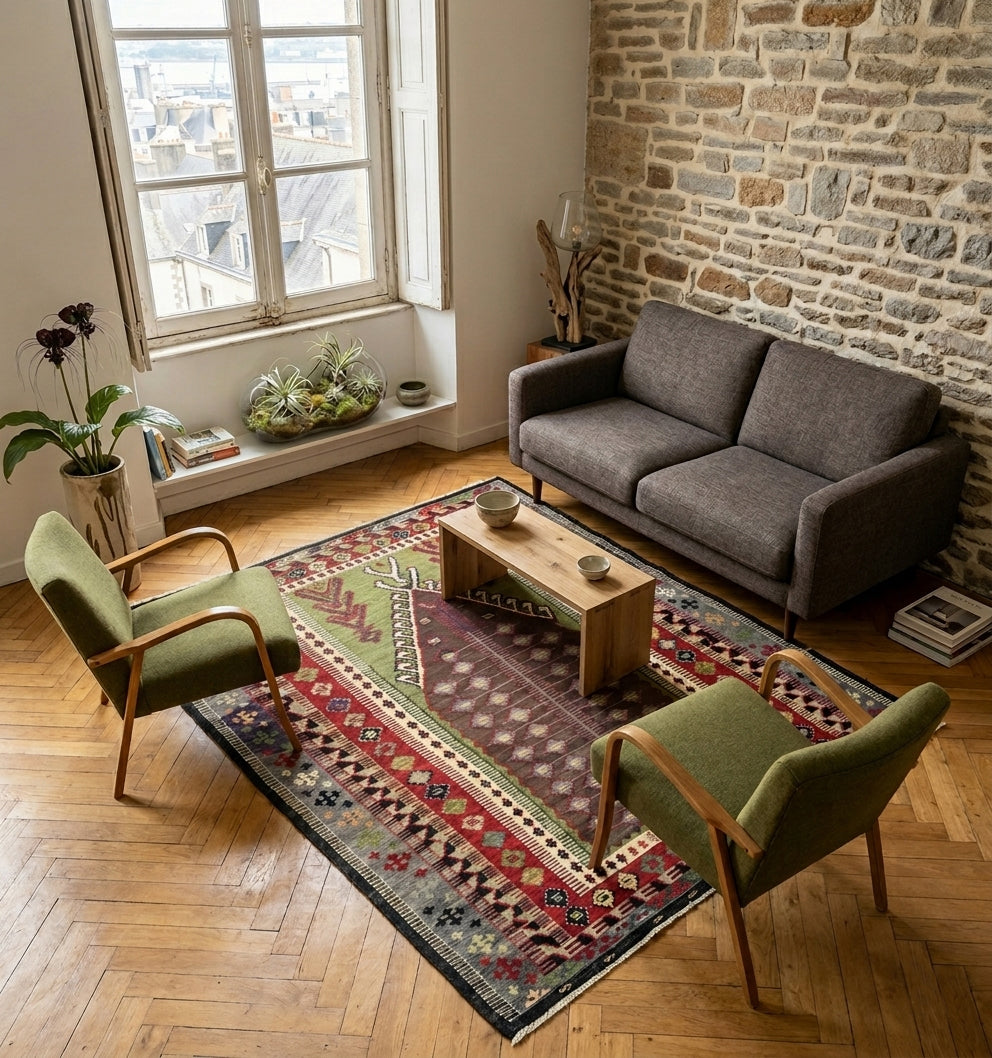 Tapis kilim Obruk vintage de 65 ans au design géométrique et couleurs naturelles. Ce chef-d'œuvre du tissage anatolien est installé dans un salon de caractère à Bordeaux, créant un dialogue parfait entre un mur en pierre authentique, un parquet en chevrons et un mobilier moderne chic.