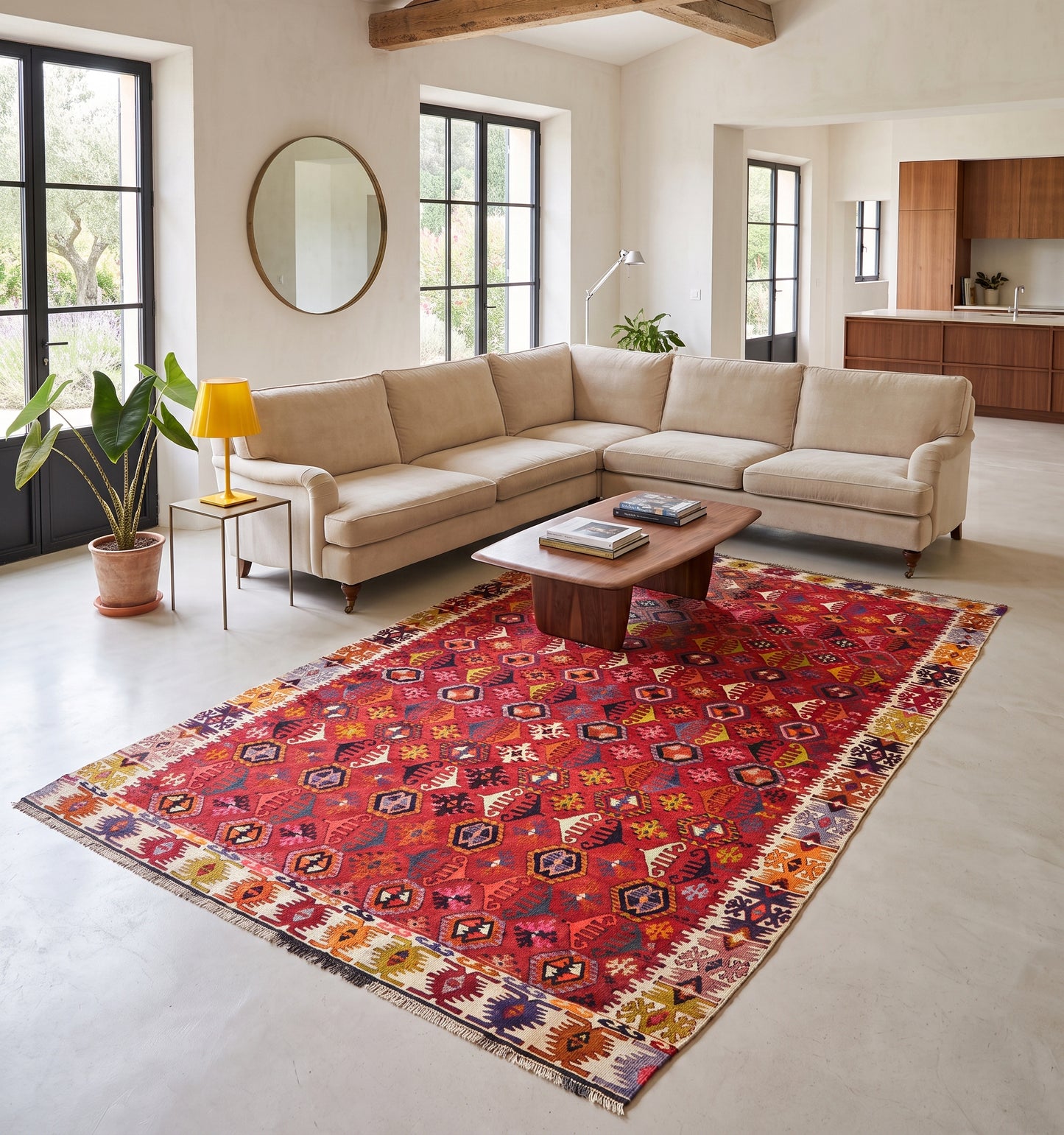 Tapis kilim ancien de Reyhanlı, tissé main en laine par des nomades d'Anatolie, foisonnement de médaillons rouge et safran, posé dans un mas près d'Uzès à la cuisine ouverte et poutres apparentes