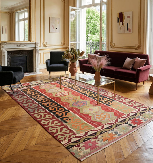 Grand tapis kilim ancien d'Anatolie aux motifs géométriques traditionnels dans un salon chic. Une pièce d'artisanat turc authentique sublimée par le contraste avec un mobilier contemporain, idéale pour une décoration d'intérieur raffinée.