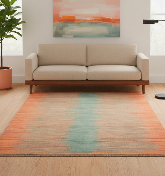 Tapis de salon en laine Art Deco avec un dégradé horizontal orange et une bande centrale bleu clair (202 x 149 cm) placé devant un canapé beige moderne et une peinture abstraite assortie