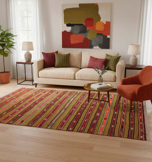 Grand tapis de salon en laine à rayures verticales rouge, vert et ocre (245 x 150 cm) mis en situation avec un canapé beige, un fauteuil orange et une toile abstraite colorée